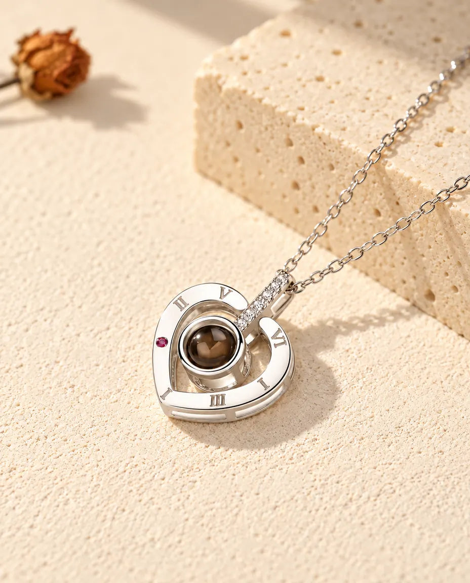 Gepersonaliseerde ketting met foto erin van 925 sterling zilver: hart met Romeinse cijfers op gips bij travertijn