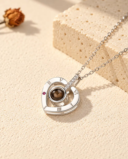 Gepersonaliseerde ketting met foto erin van 925 sterling zilver: hart met Romeinse cijfers op gips bij travertijn