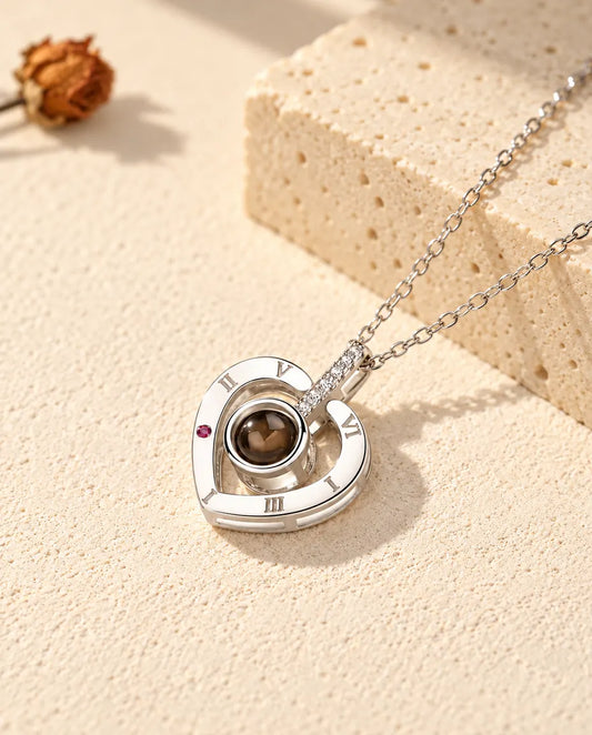 Gepersonaliseerde ketting met foto erin van 925 sterling zilver: hart met Romeinse cijfers op gips bij travertijn