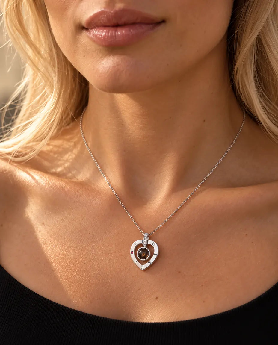 Vrouw in een zwarte gebreide top draagt de zilveren ketting met een hart met Romeinse cijfers