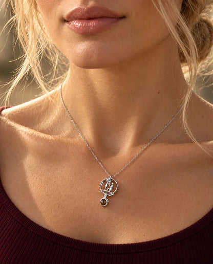 Vrouw in een bordeauxrode top draagt de zilverkleurige ketting met het huwelijksaanzoek