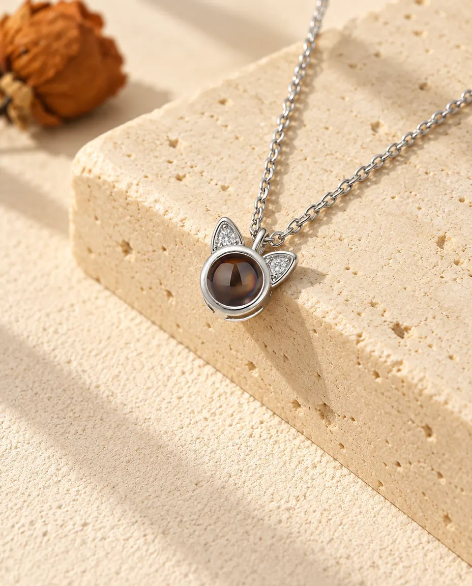 Zilverkleurige ketting met foto erin en kattenoortjes die bezet zijn met zirkonia