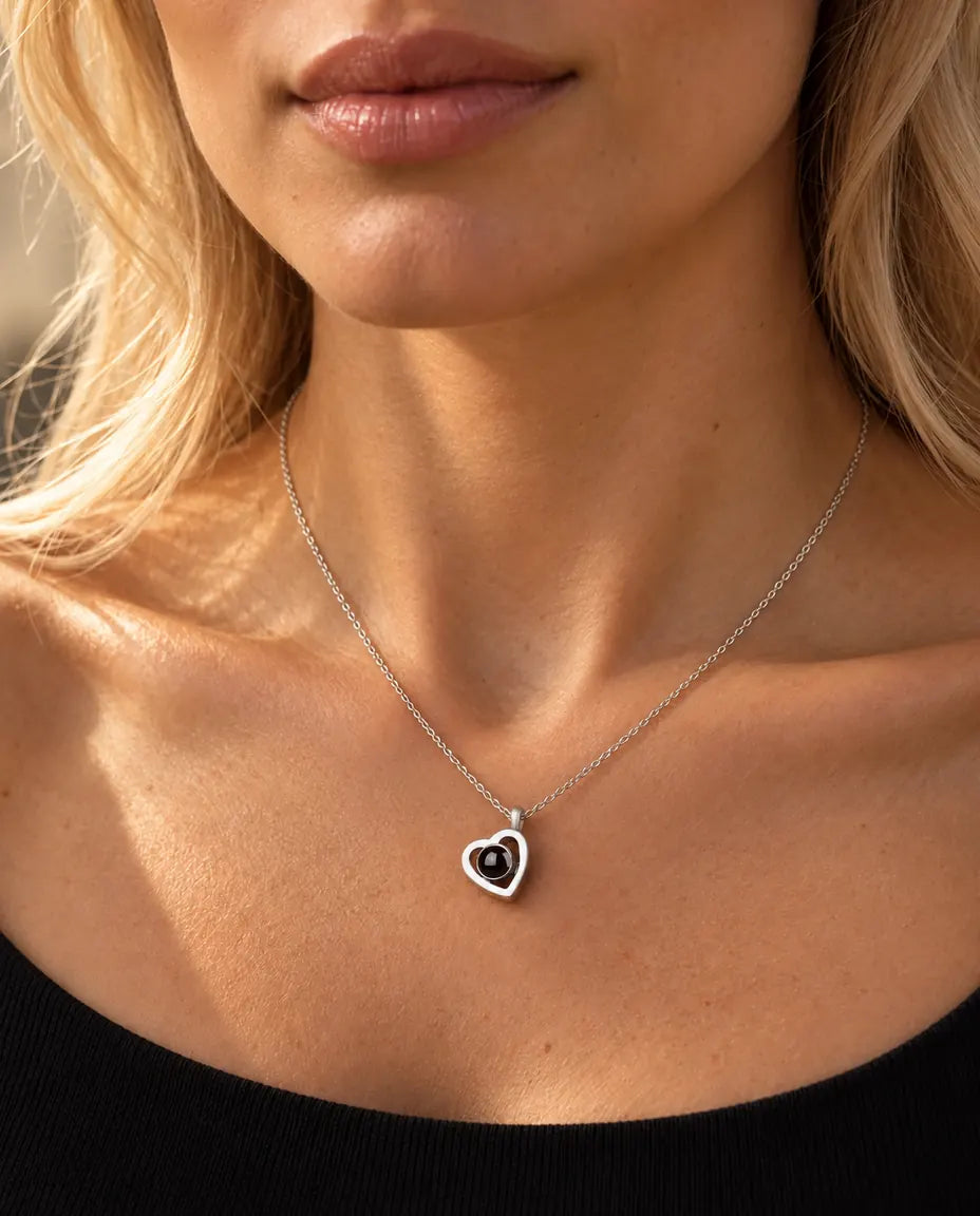 Vrouw in een zwarte gebreide top draagt het kleine dubbele hartje van 925 sterling zilver met foto erin