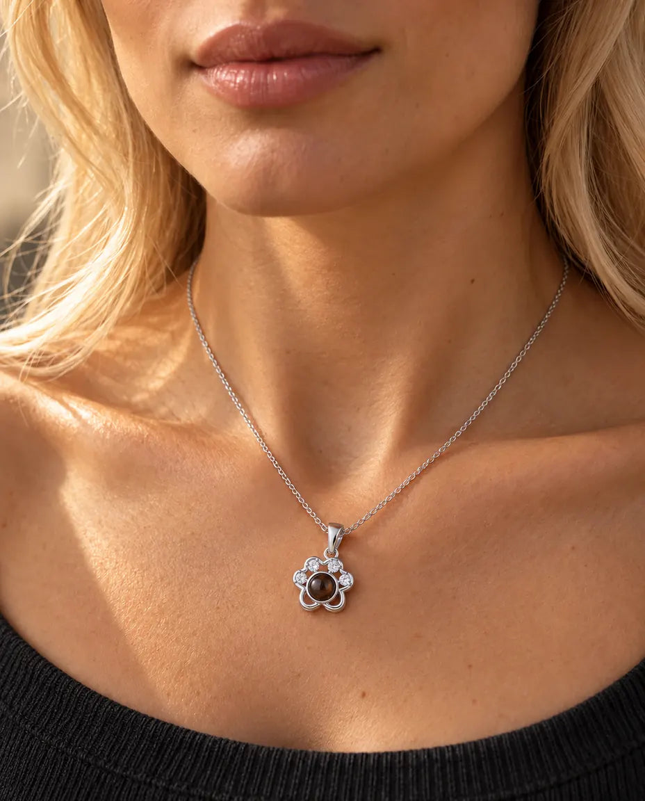 Vrouw in een antracietgrijze gebreide top draagt de zilverkleurige ketting met pootje