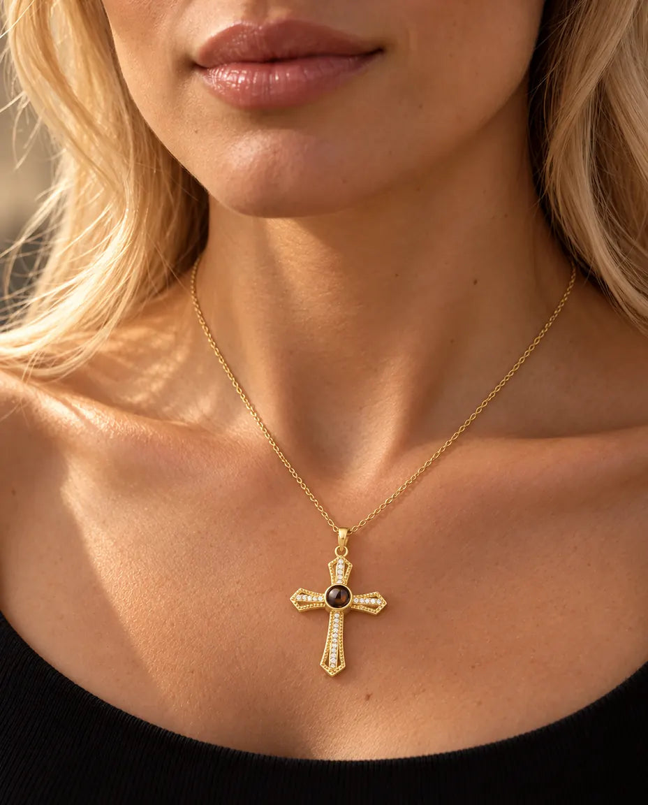 Blonde vrouw in een zwarte top draagt de goudkleurige ketting met kruis van zirkonia en foto erin