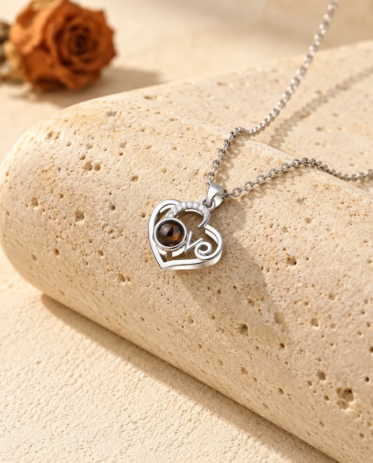 Gepersonaliseerde zilverkleurige ketting met foto erin: open Love-hart met een boogje zirkonia, op een blok travertin