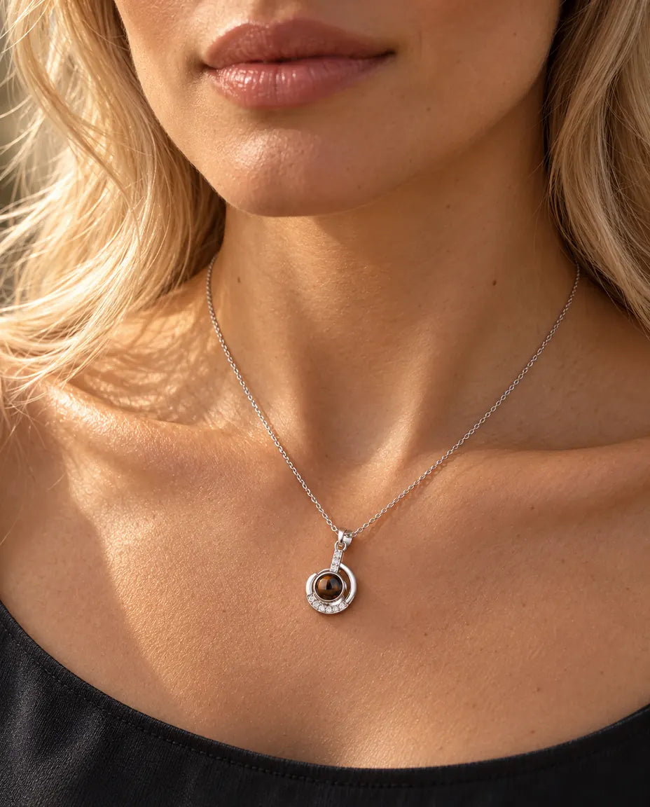 Vrouw in een antracietgrijze top draagt de fijne zilverkleurige ketting met maansikkel