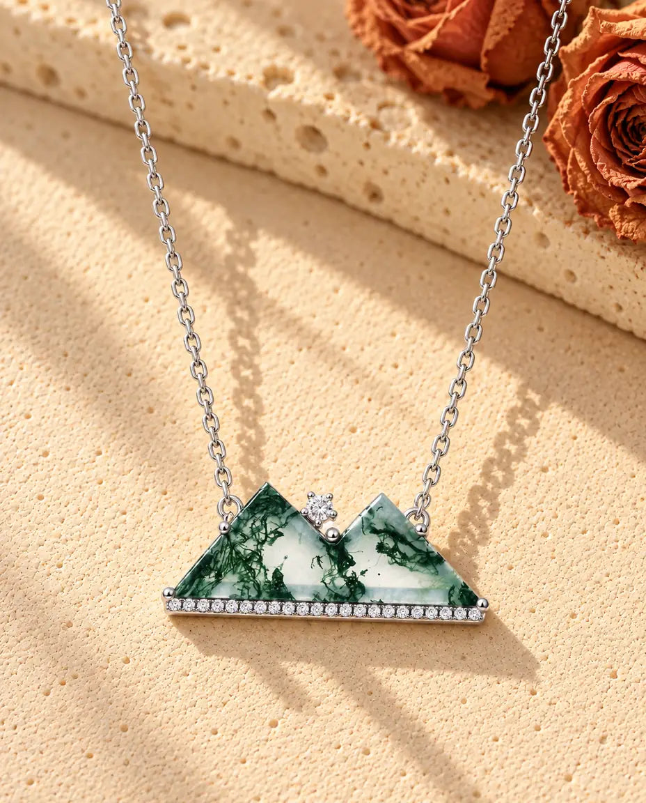 Mosagaat Ketting met Bergtoppen in 925 Sterling Zilver - liggend op een licht gestructureerd oppervlak naast een blok travertijn
