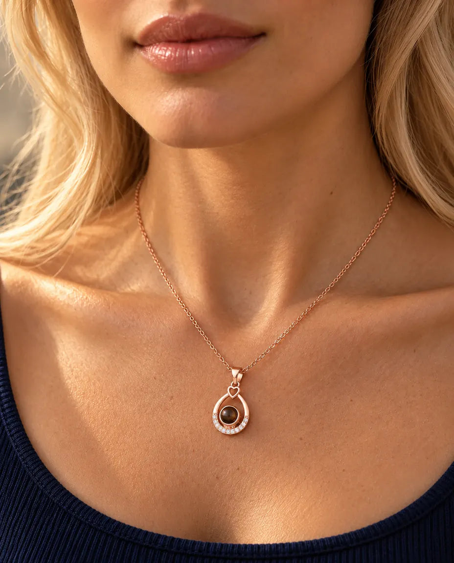 Vrouw in een marineblauwe top draagt de roségoudkleurige ketting met open druppel