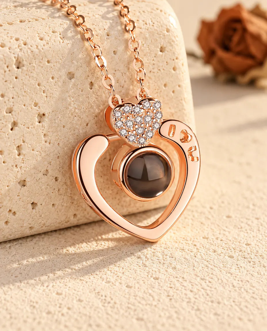 Gepersonaliseerde roségoudkleurige ketting met foto erin: open hart met I love U, leunend tegen travertijn