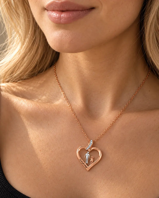 Vrouw in een zwart topje draagt de roségoudkleurige hartketting met papa en dochter