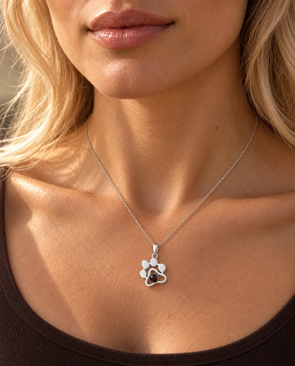 Vrouw in een bruine top draagt de zilveren ketting met pootafdruk en een foto van haar huisdier