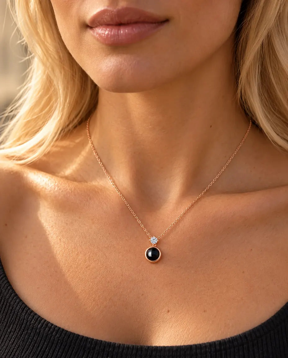 Vrouw in een antracietgrijze top draagt de fijne roségoudkleurige ketting met solitair