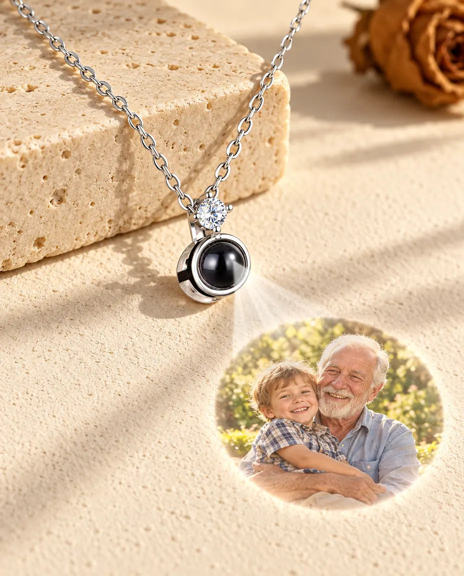 Zilverkleurige ketting met solitair projecteert een foto van opa en kleinzoon op gips