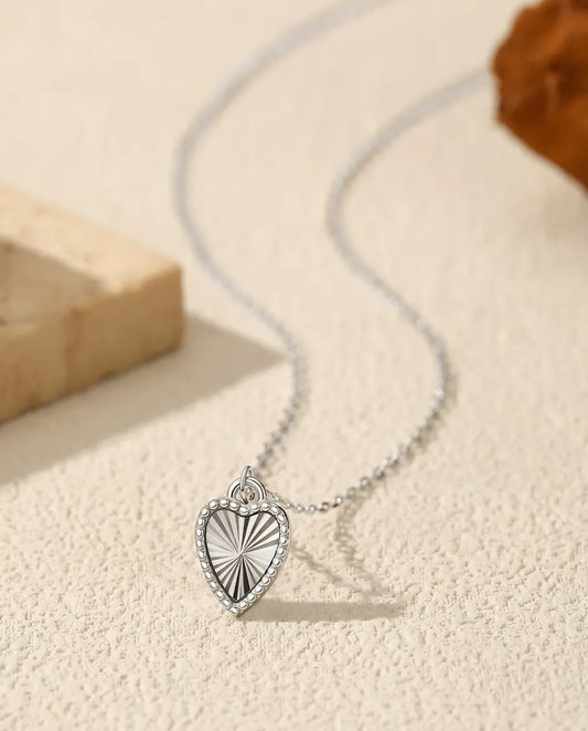 Ketting met Hartjeshanger in 925 Sterling Zilver - hanger op een licht oppervlak naast een travertijnplaat