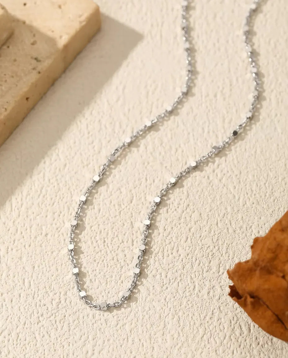Ketting met Pailletten in 925 Sterling Zilver - op een licht oppervlak naast een travertijnplaat