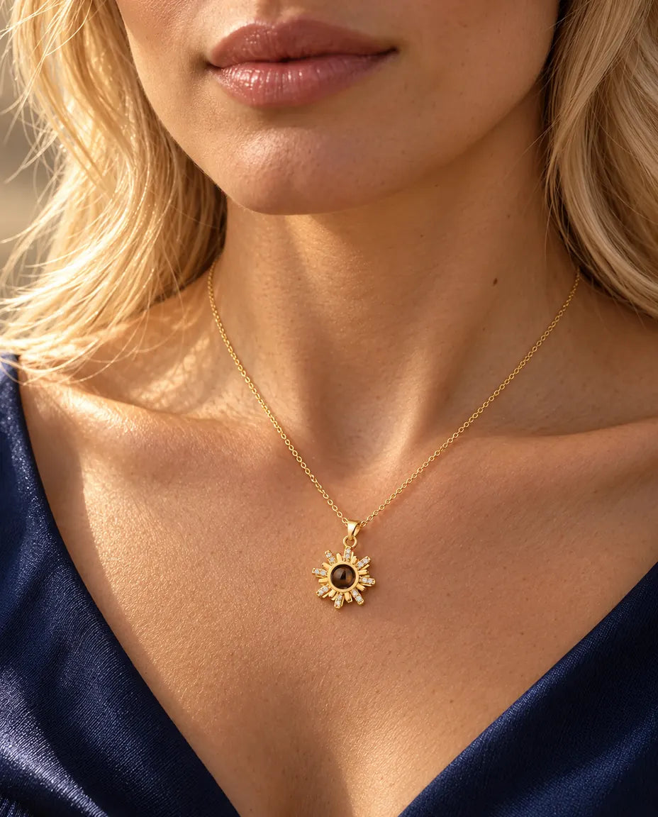 Vrouw in een marineblauwe top draagt de goudkleurige ketting met stralend zonnetje