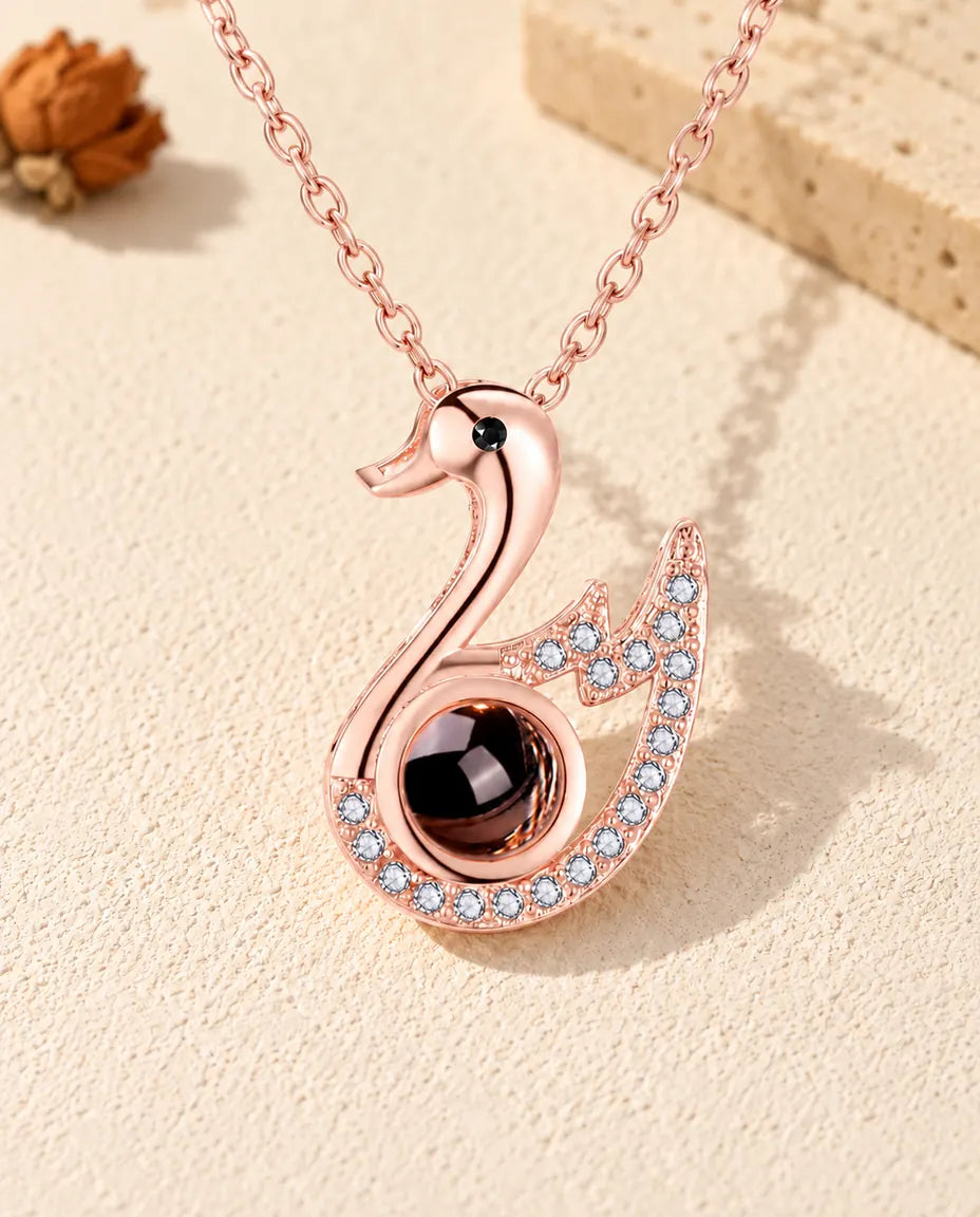 Vooraanzicht van de roségoudkleurige ketting met zwaan en foto erin