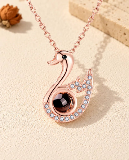 Vooraanzicht van de roségoudkleurige ketting met zwaan en foto erin
