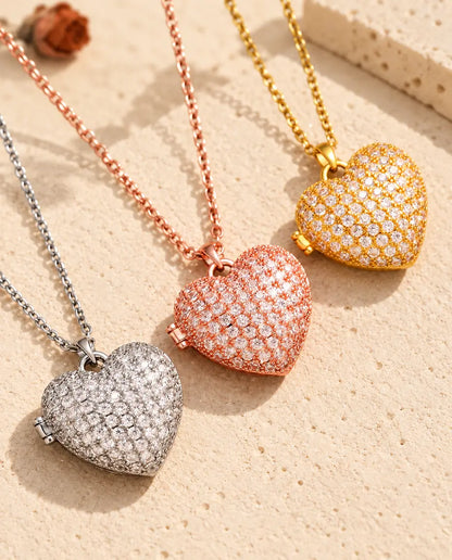 Pavé hartmedaillons in zilver-, roségoud- en goudkleurig, schuin op crèmekleurig gips