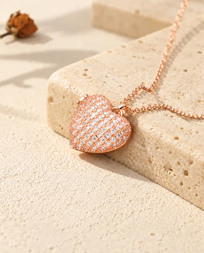 Ketting met een roségoudkleurig pavé hartmedaillon op travertin in warm zonlicht
