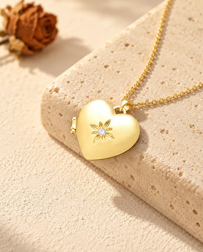 Ketting met een goudkleurig gesatineerd hartmedaillon, liggend op een blok travertin
