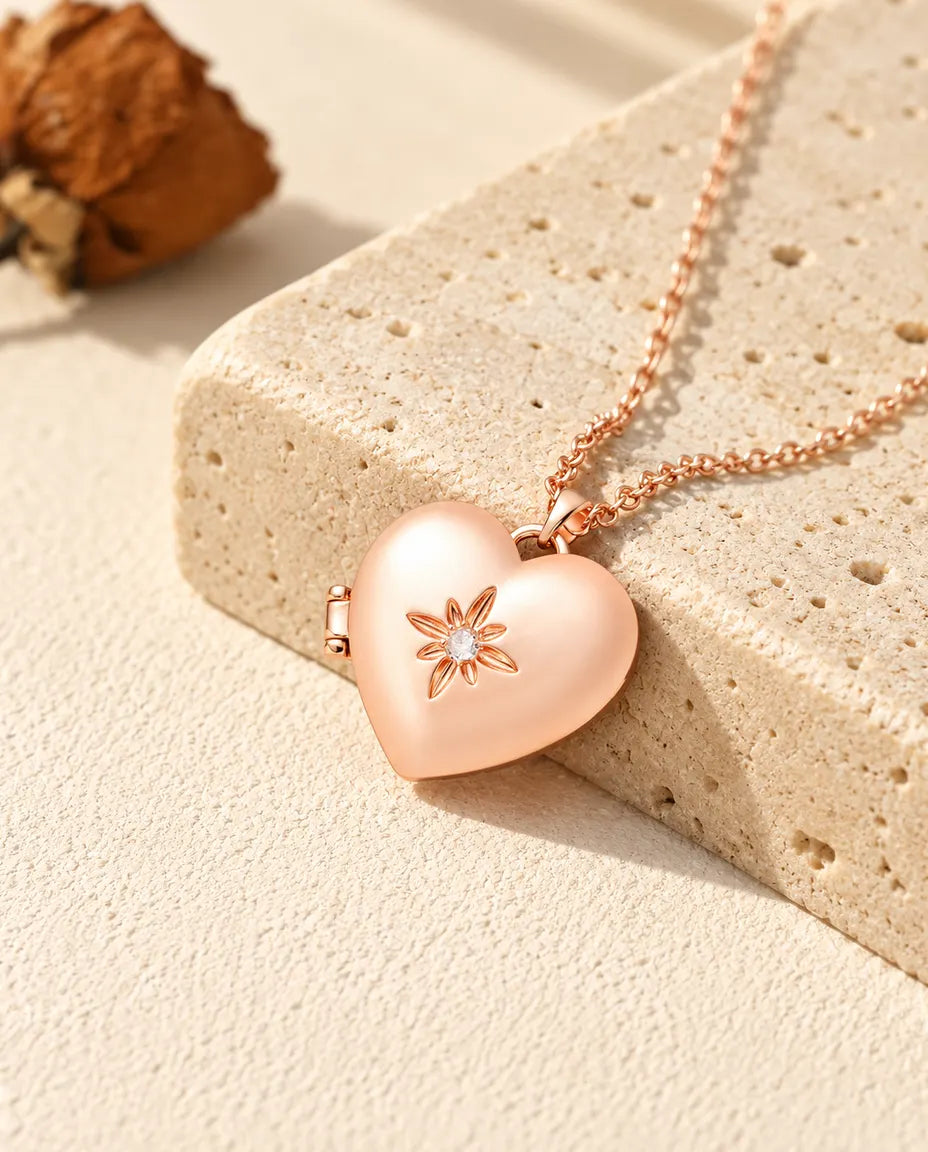 Ketting met een roségoudkleurig gesatineerd hartmedaillon op travertin in warm zonlicht