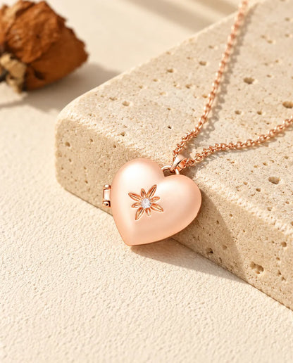 Ketting met een roségoudkleurig gesatineerd hartmedaillon op travertin in warm zonlicht