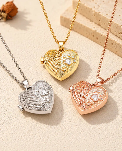 De drie kleuren van de ketting met hartmedaillon met engelenvleugel en poot samen uitgestald op gips