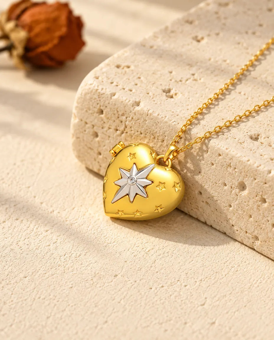 Ketting met een goudkleurig hartmedaillon met poolster, liggend op een blok travertin