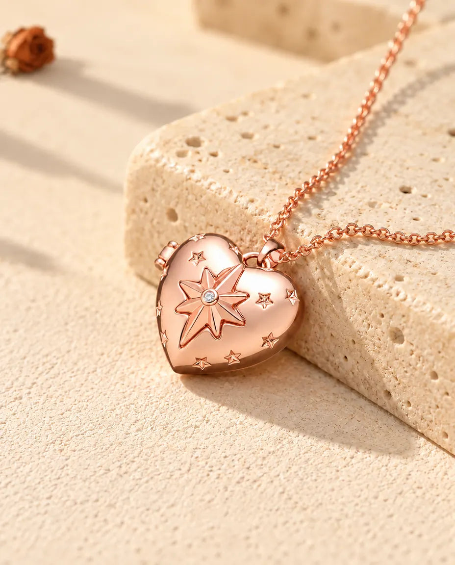 Ketting met een roségoudkleurig hartmedaillon met poolster op travertin in warm zonlicht