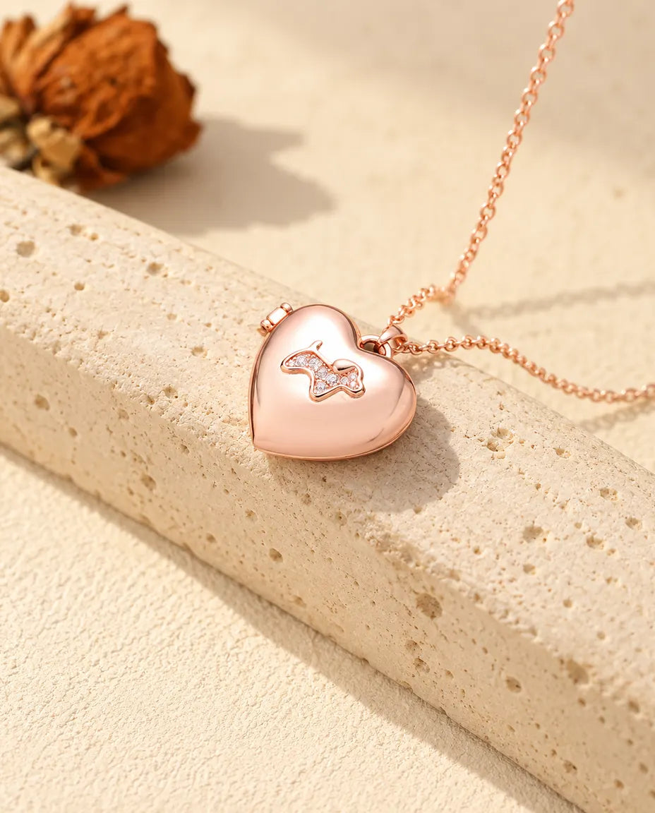 Ketting met een roségoudkleurig hartmedaillon met puppy op travertin in warm zonlicht