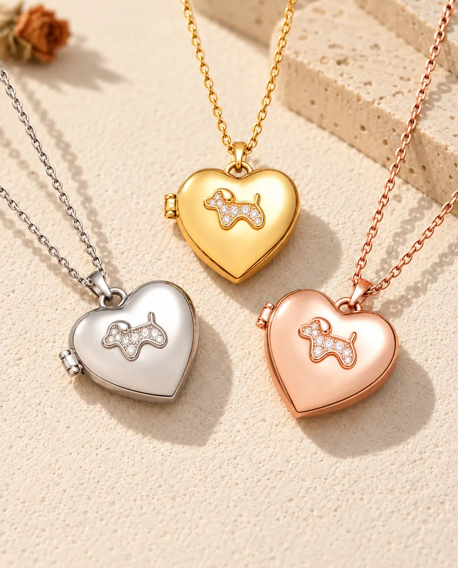 De drie kleuren van de ketting met hartmedaillon met puppy, naast elkaar op gips
