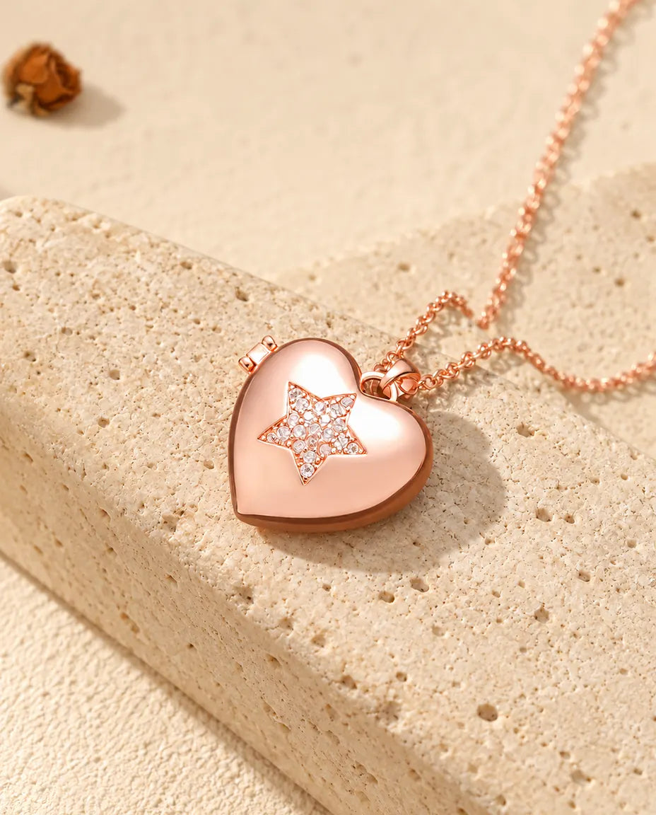 Ketting met een roségoudkleurig hartmedaillon met ster op travertin in warm zonlicht