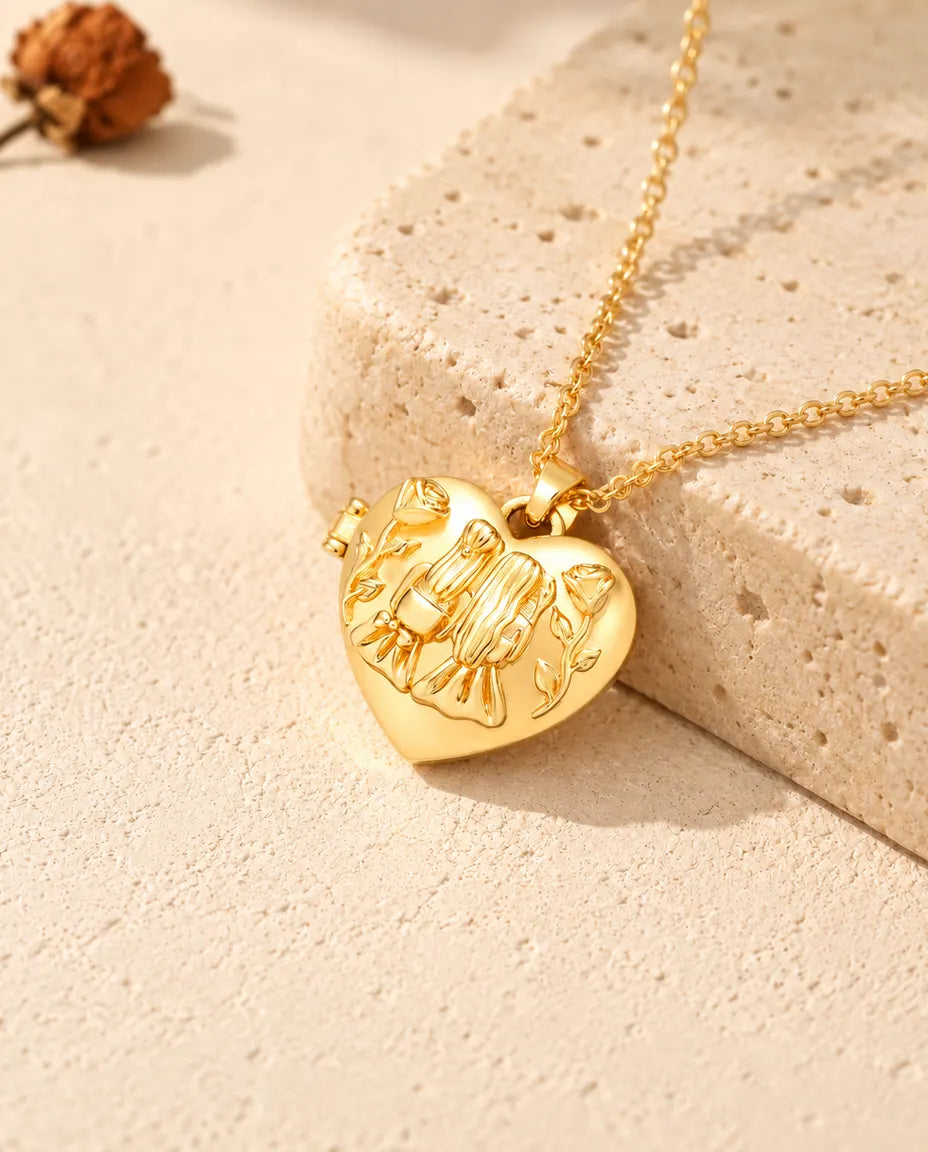 Goudkleurige ketting met hartmedaillon met twee zusjes, neergelegd op een blok travertin