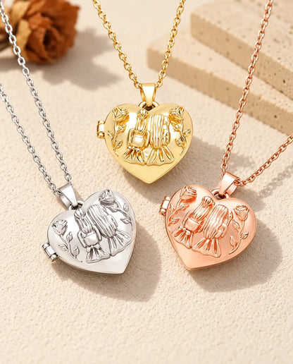 De drie kleuren van de ketting met hartmedaillon met twee zusjes samen uitgestald op gips