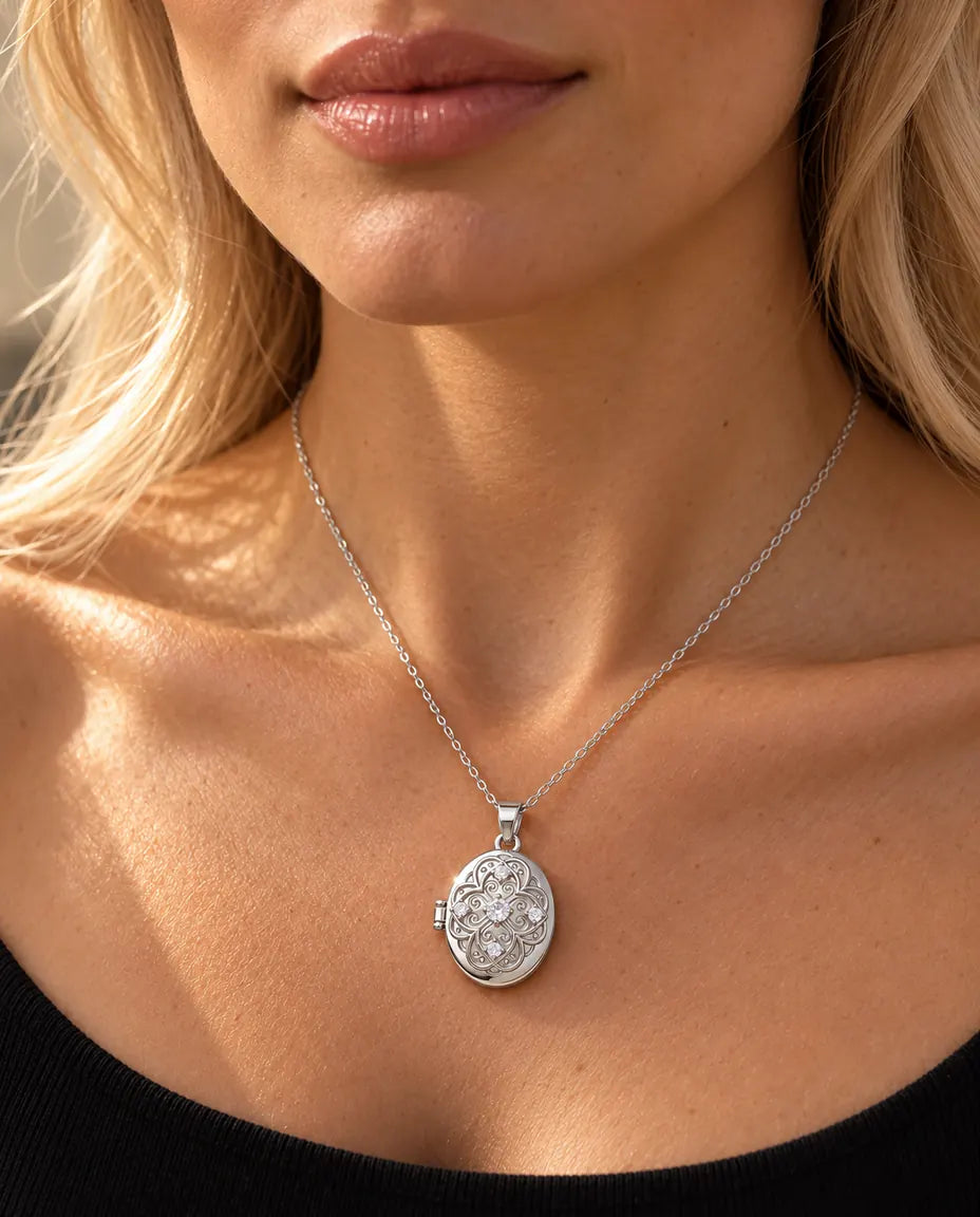 Vrouw in een zwart gebreid topje draagt de zilverkleurige ketting met het ovale filigraanmedaillon