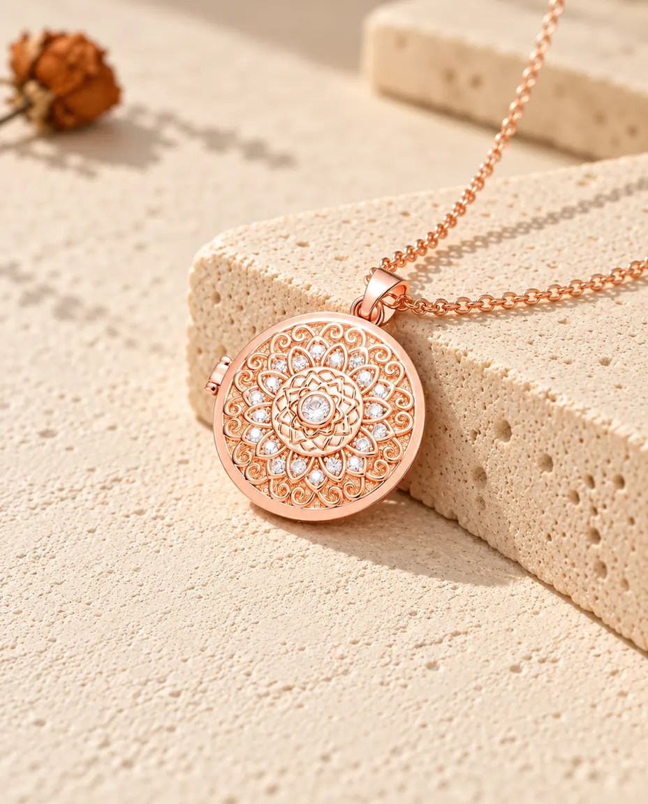 Roségoudkleurige ketting met medaillon met mandalabloem op travertin in warm zonlicht