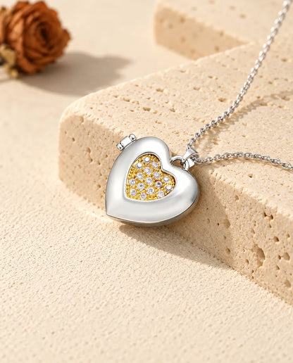 Gepersonaliseerd zilverkleurig hartmedaillon met een goudkleurig pavé hartje op een blok travertin