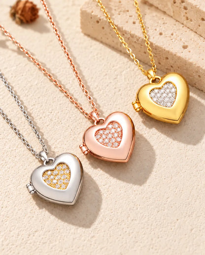 Hartmedaillons met pavé hartje in zilver-, roségoud- en goudkleurig, schuin op crèmekleurig gips