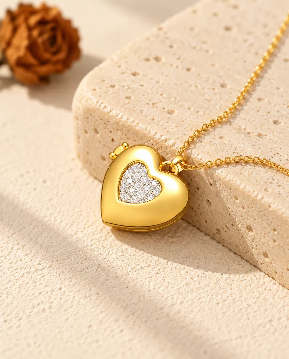 Ketting met een goudkleurig hartmedaillon met pavé hartje, liggend op een blok travertin