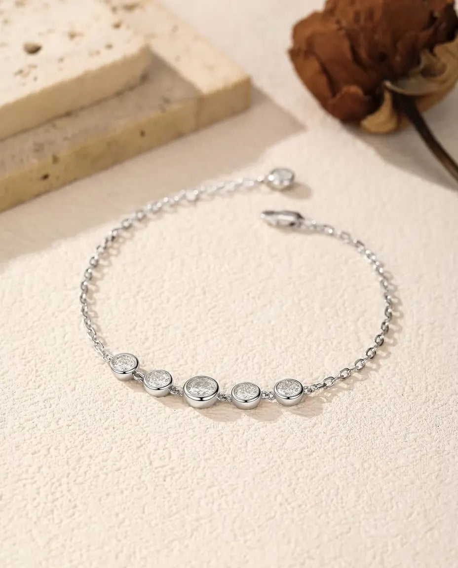 Moissanite Armband in Kastzetting in 925 Sterling Zilver - los neergelegd op een licht oppervlak met sluiting en verlengketting
