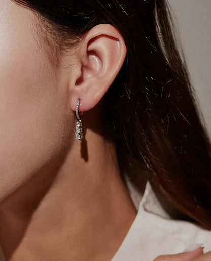 Moissanite Creolen met Drie Hangende Stenen in 925 Sterling Zilver - gedragen in het oor van een model, close-up