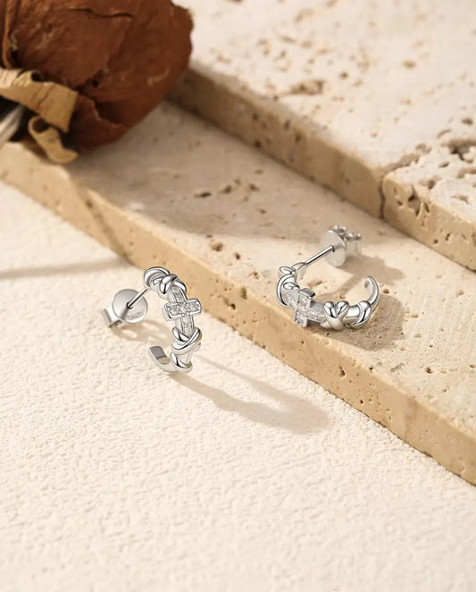 Moissanite Creolen met Kruisje in 925 Sterling Zilver - het paar naast elkaar op een licht gestructureerd oppervlak