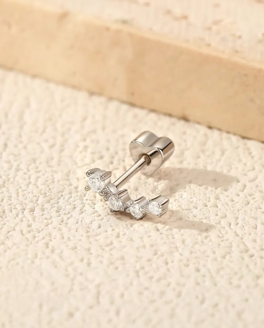 Moissanite Ear Climber Oorknopjes in 925 Sterling Zilver - op een licht gestructureerd oppervlak naast een travertijnplaat