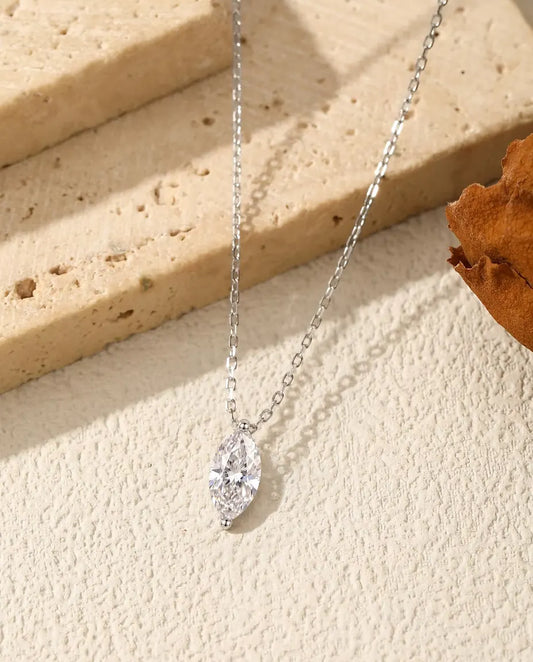 Moissanite Ketting Marquise van 1 ct in 925 Sterling Zilver - hanger over de rand van een travertijnplaat