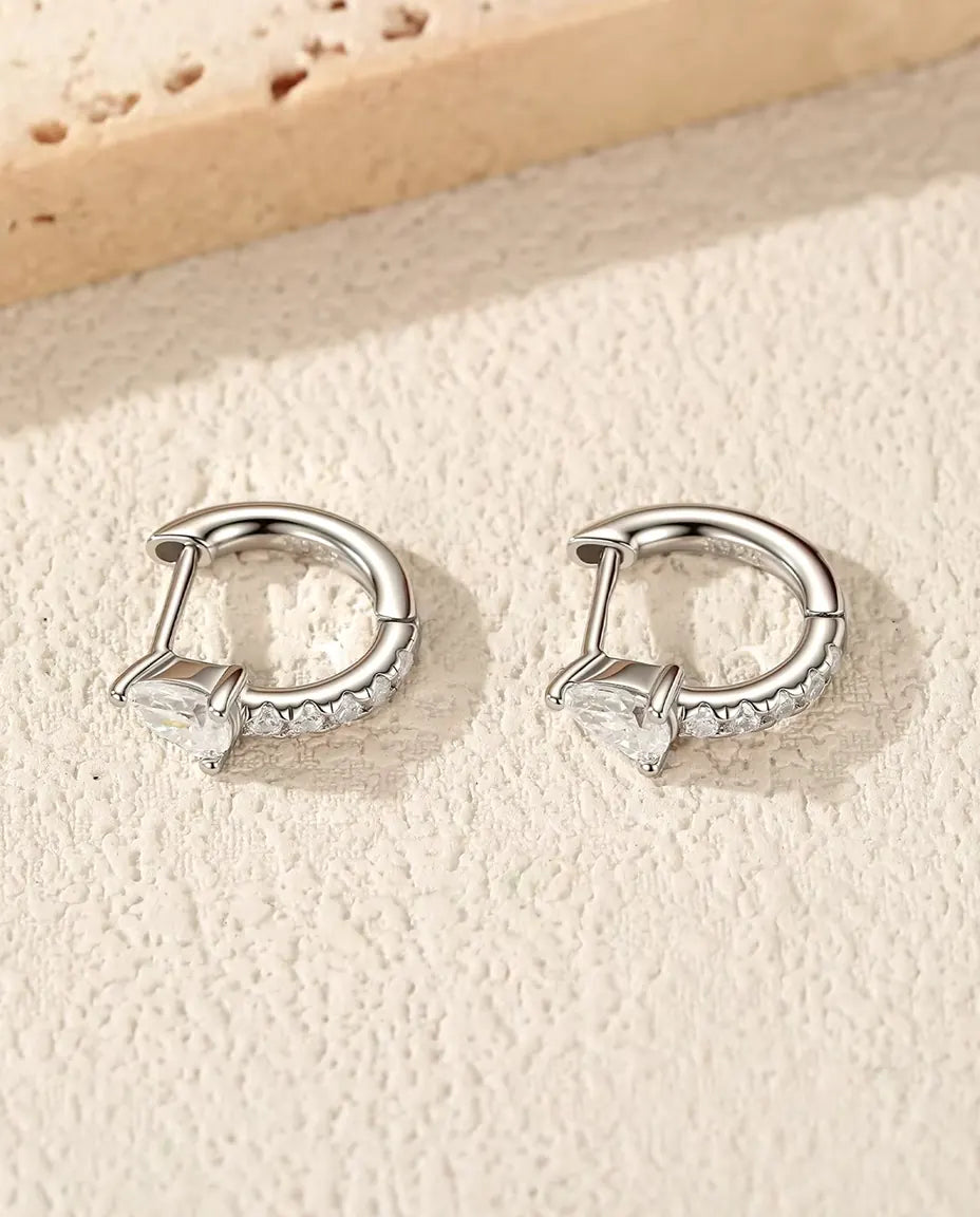 Moissanite Mini Creolen Peervorm in 925 Sterling Zilver - het paar op een licht gestructureerd oppervlak