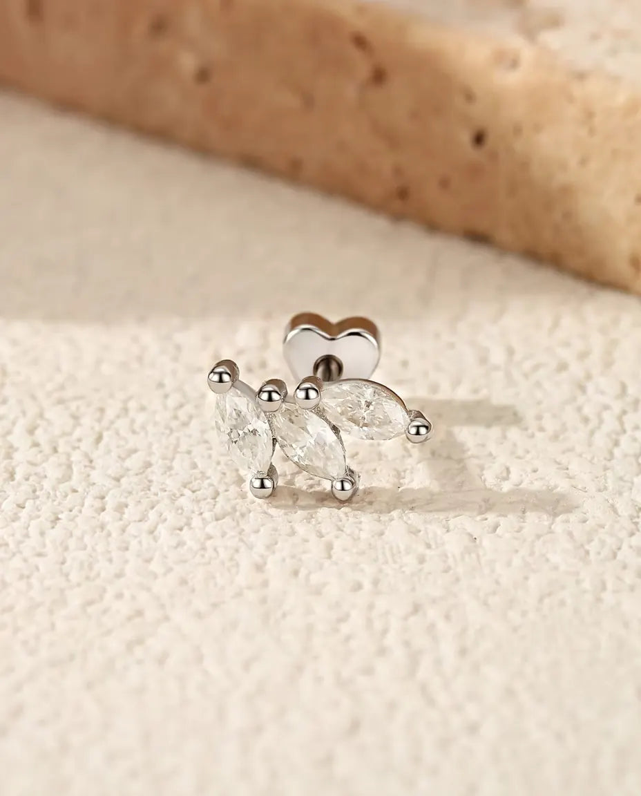 Moissanite Oorknopjes Blaadje in 925 Sterling Zilver - op een licht gestructureerd oppervlak naast een travertijnplaat