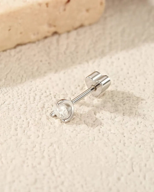 Moissanite Oorknopjes Rond met Zilveren Boogje in 925 Sterling Zilver - op zijn kant op een licht gestructureerd oppervlak, hartvormig achterkantje op de stift