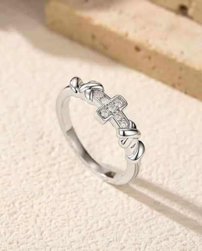 Moissanite Ring met Kruis in 925 Sterling Zilver - rechtop op een licht gestructureerd oppervlak